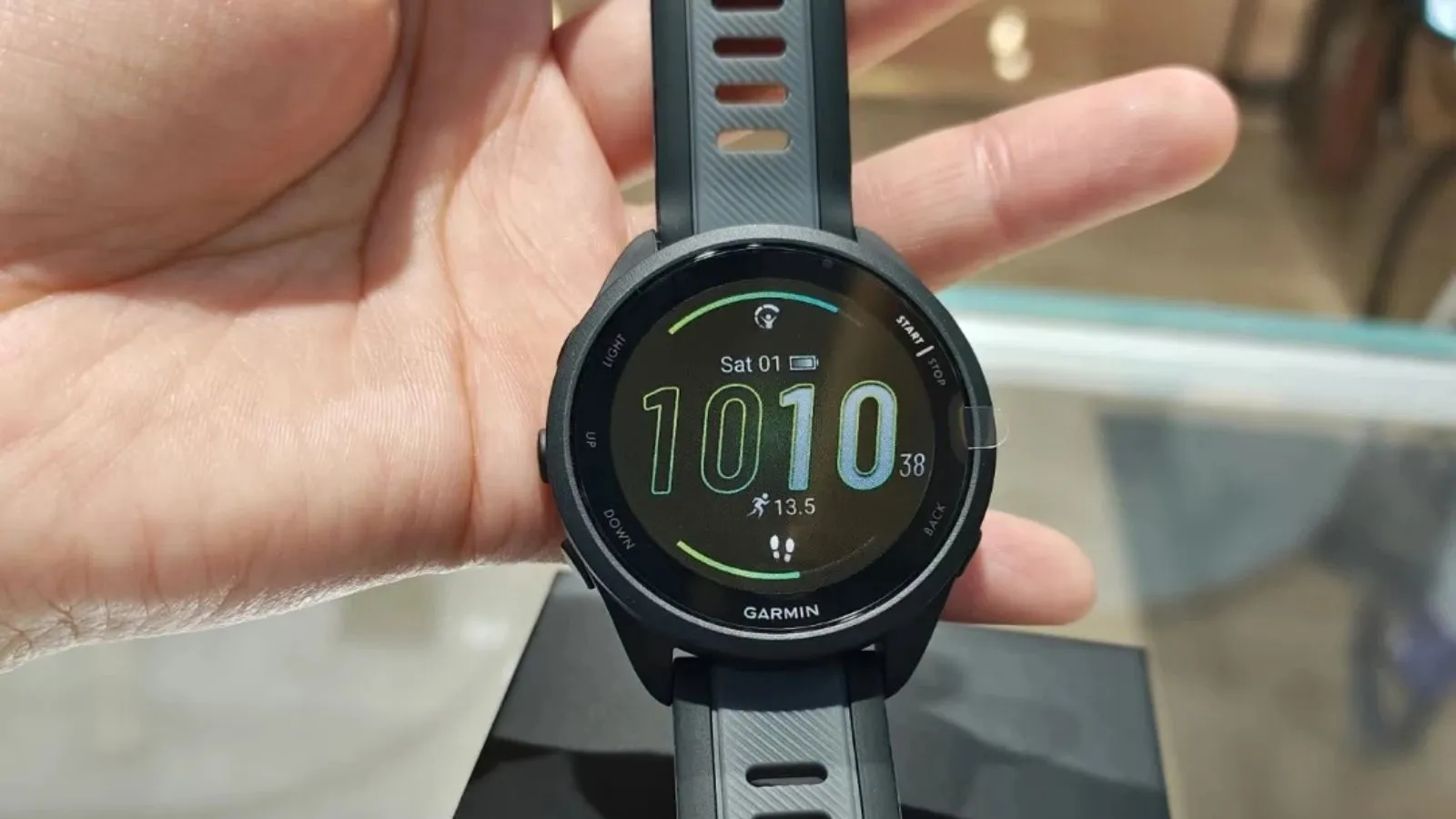 Reloj deportivo Garmin Forerunner 165 con correa negra sobre fondo claro