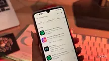 Mano sosteniendo un teléfono mientras navega por la categoría Música y audio de Google Play Store