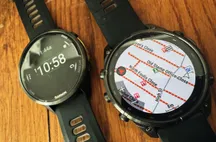 Garmin Fenix 9 Pro mostrando un mapa con nombres de calles junto a un Forerunner 970 con cronómetro