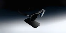 Las gafas XREAL Aura con su módulo externo (puck) bajo la montura, sobre un fondo gris