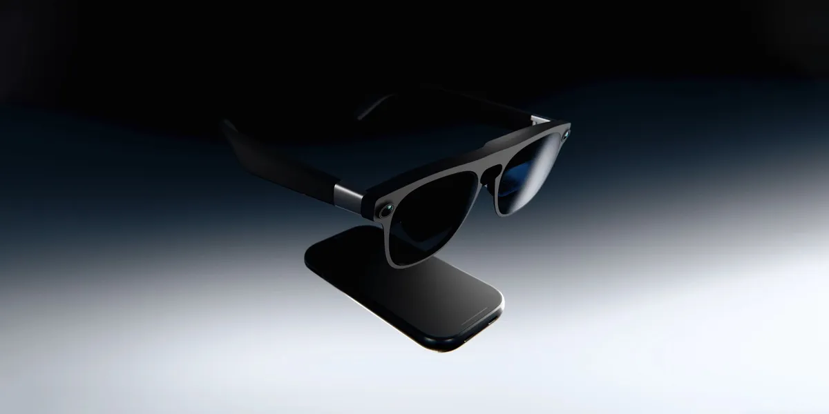 Las gafas XREAL Aura con su módulo externo (puck) bajo la montura, sobre un fondo gris