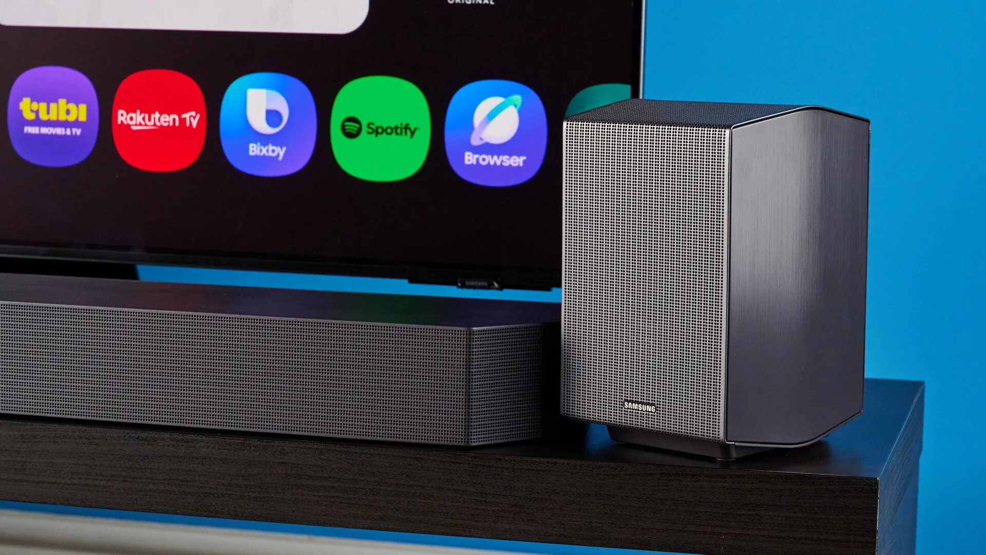Barra y uno de los altavoces traseros situados delante del televisor