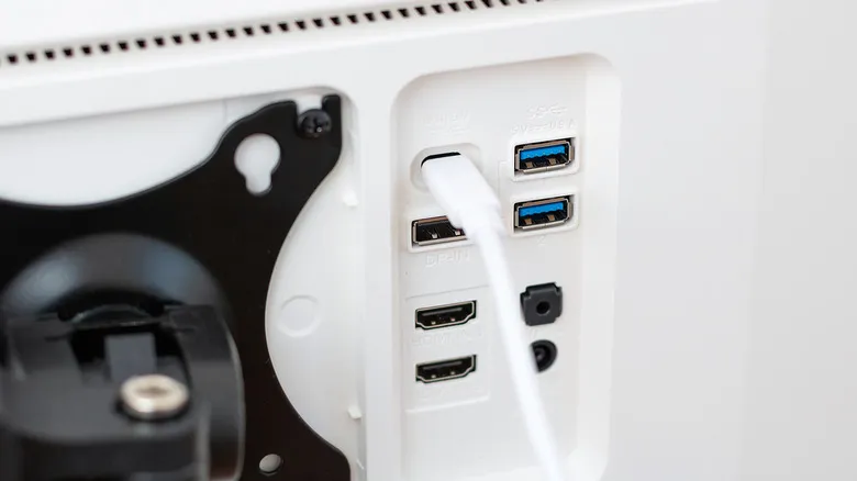 Cable USB-C conectado a la parte trasera de una pantalla de ordenador