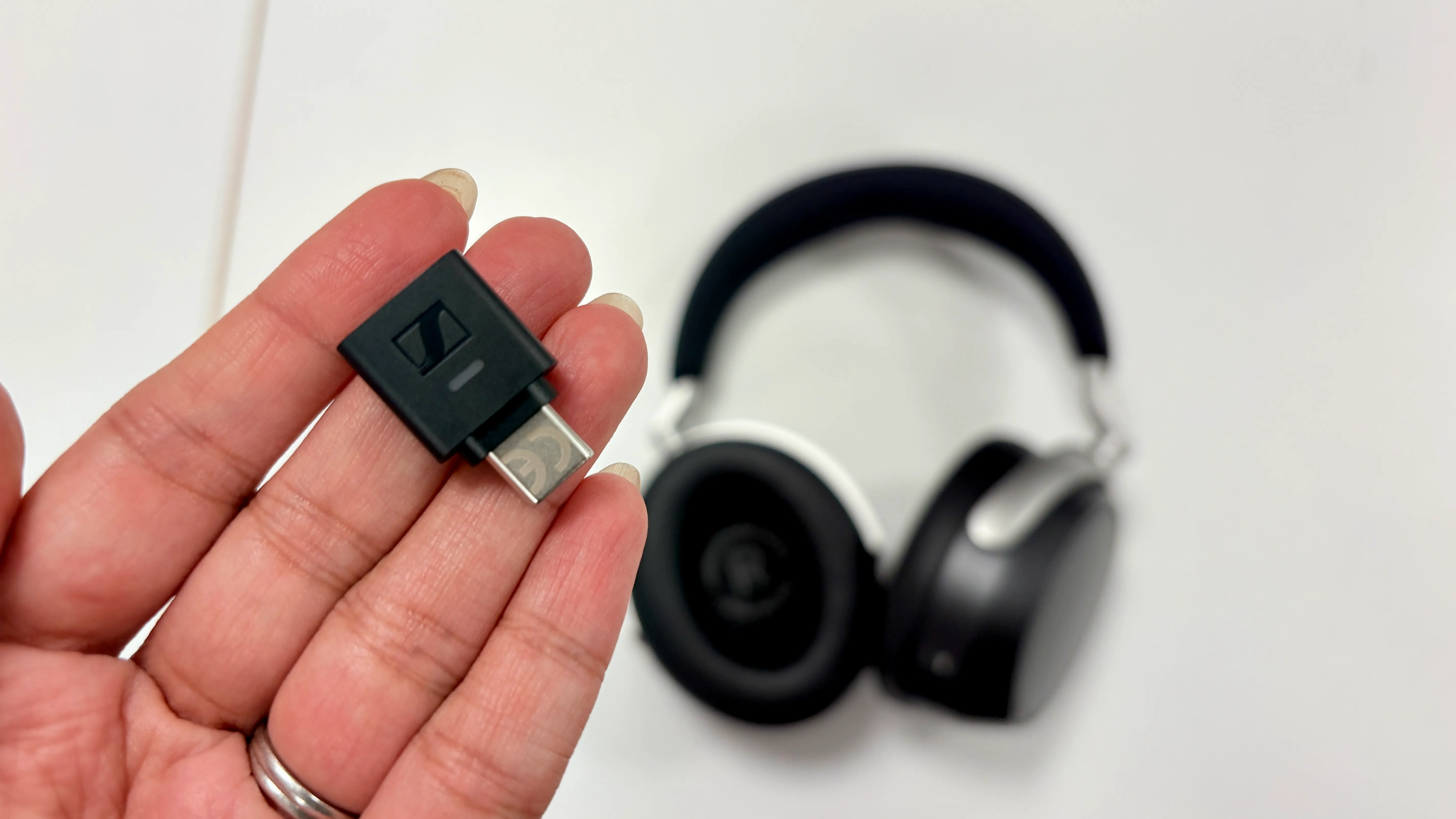 Dongle BTD 700 conectado a un teléfono junto a los auriculares HDB 630
