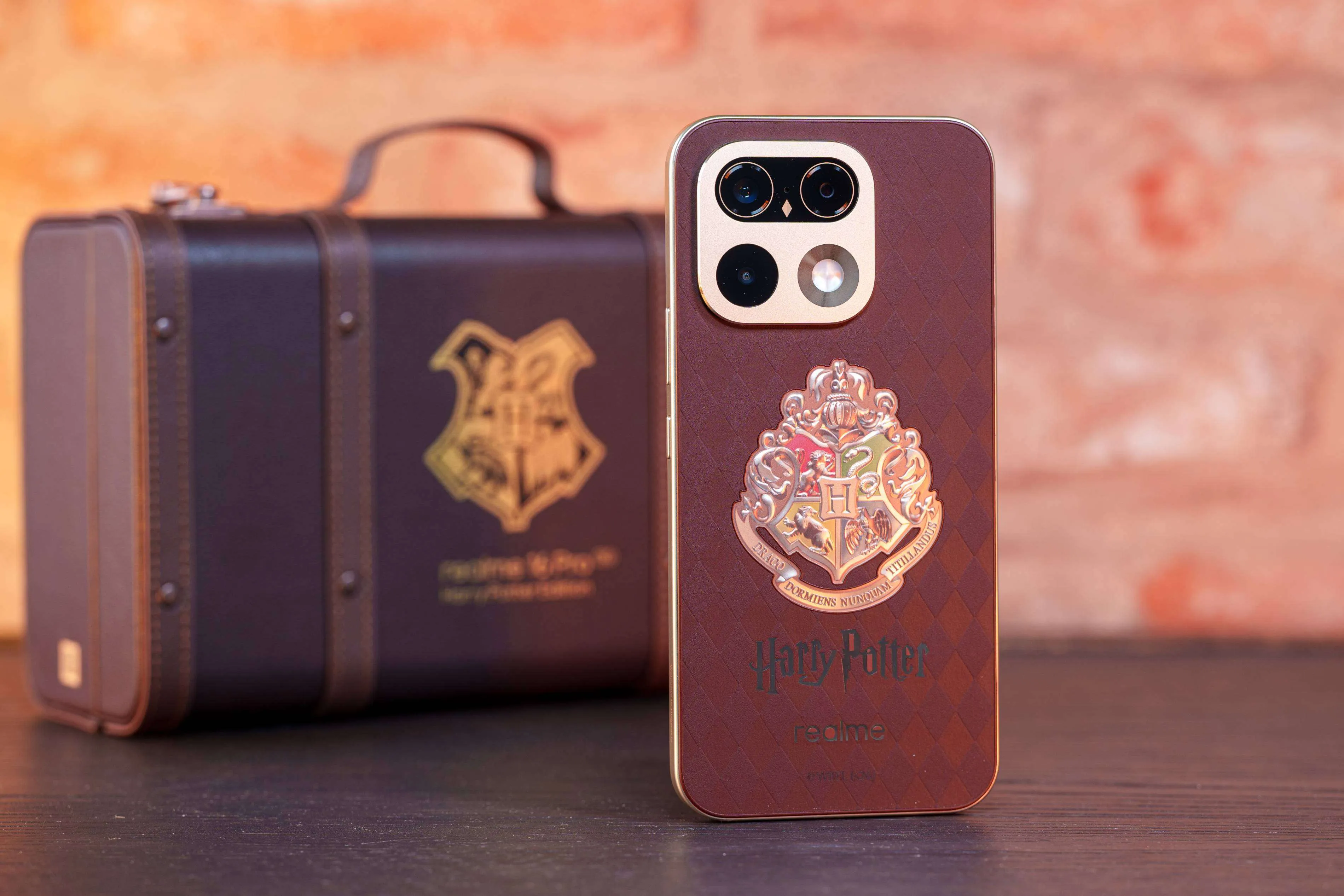 La Realme 16 Pro Harry Potter Edition de pie junto a la maleta de Hogwarts
