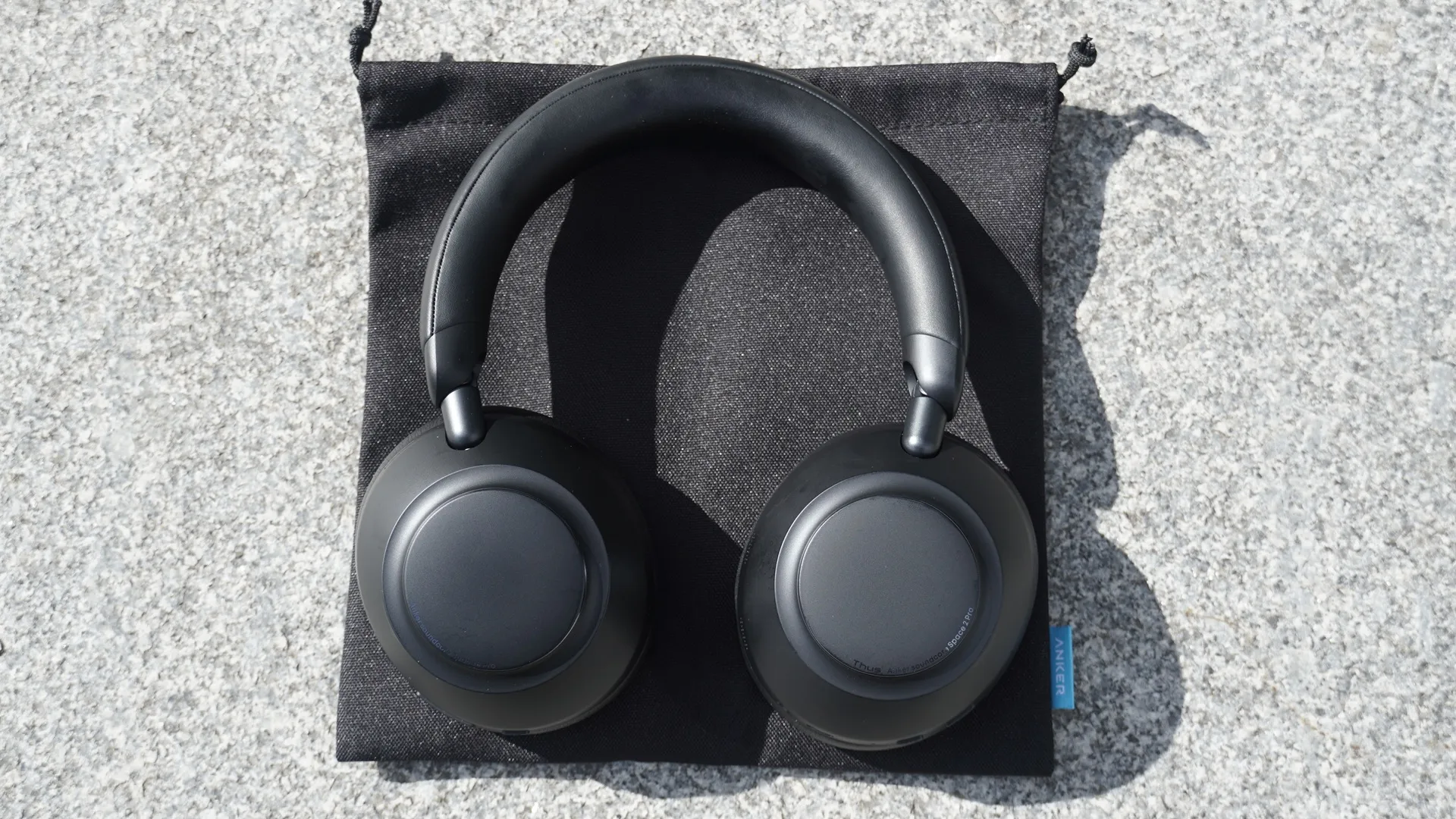 Los Soundcore Space 2 Pro apoyados sobre su bolsa de transporte de tela