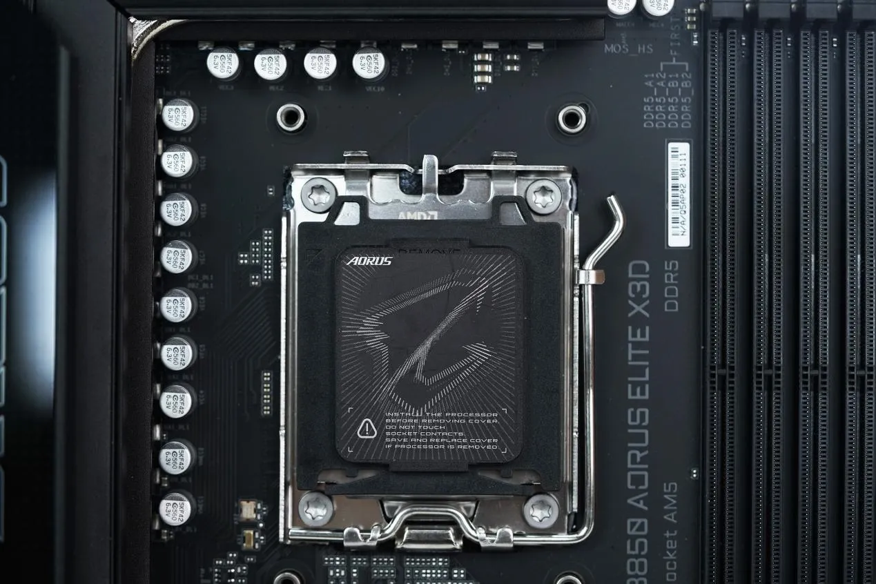 Zócalo AM5 con la tapa de protección AORUS y los condensadores del VRM alrededor