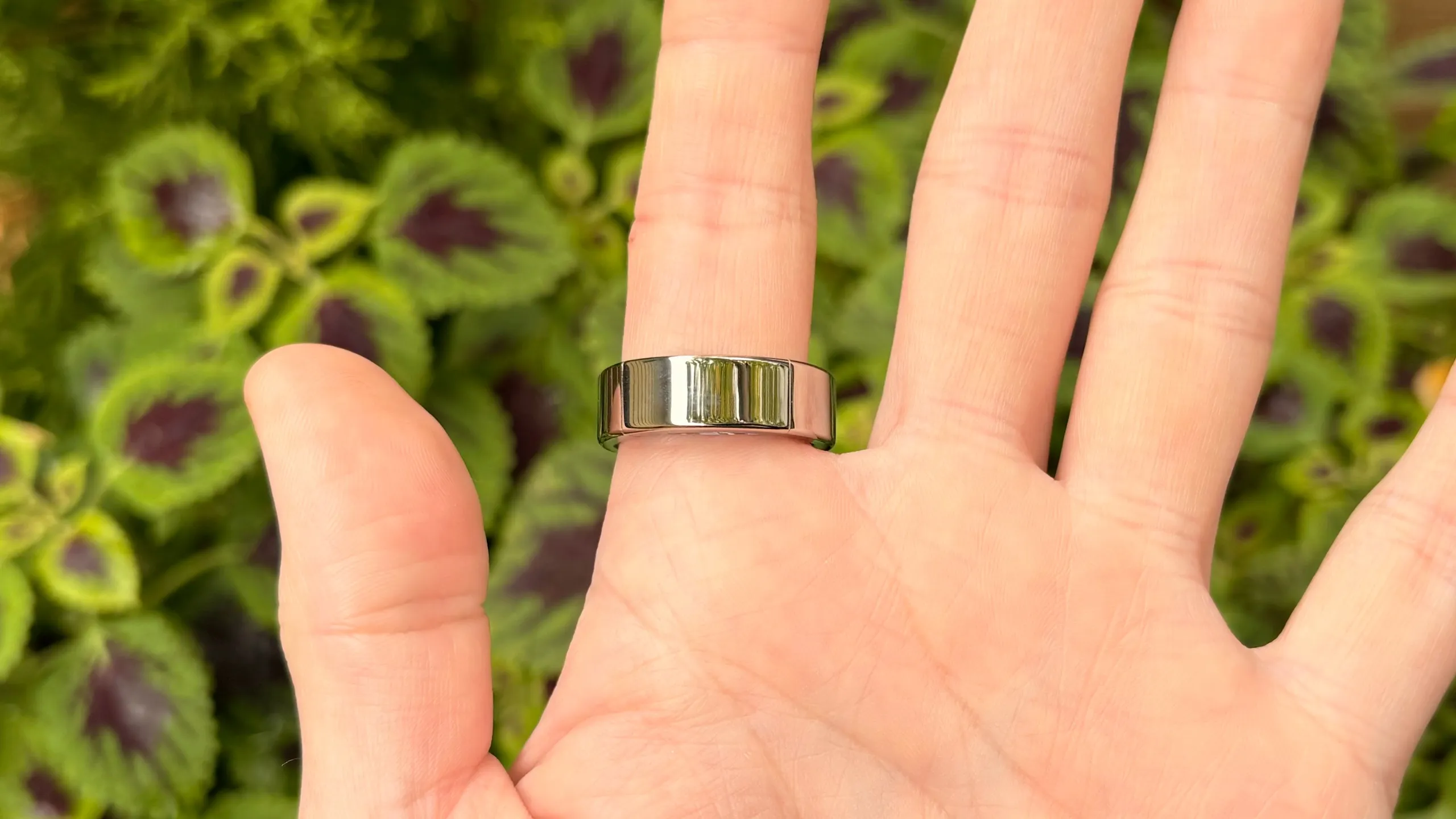 Ultrahuman Ring Pro plateado en un dedo durante una fotografía en el exterior