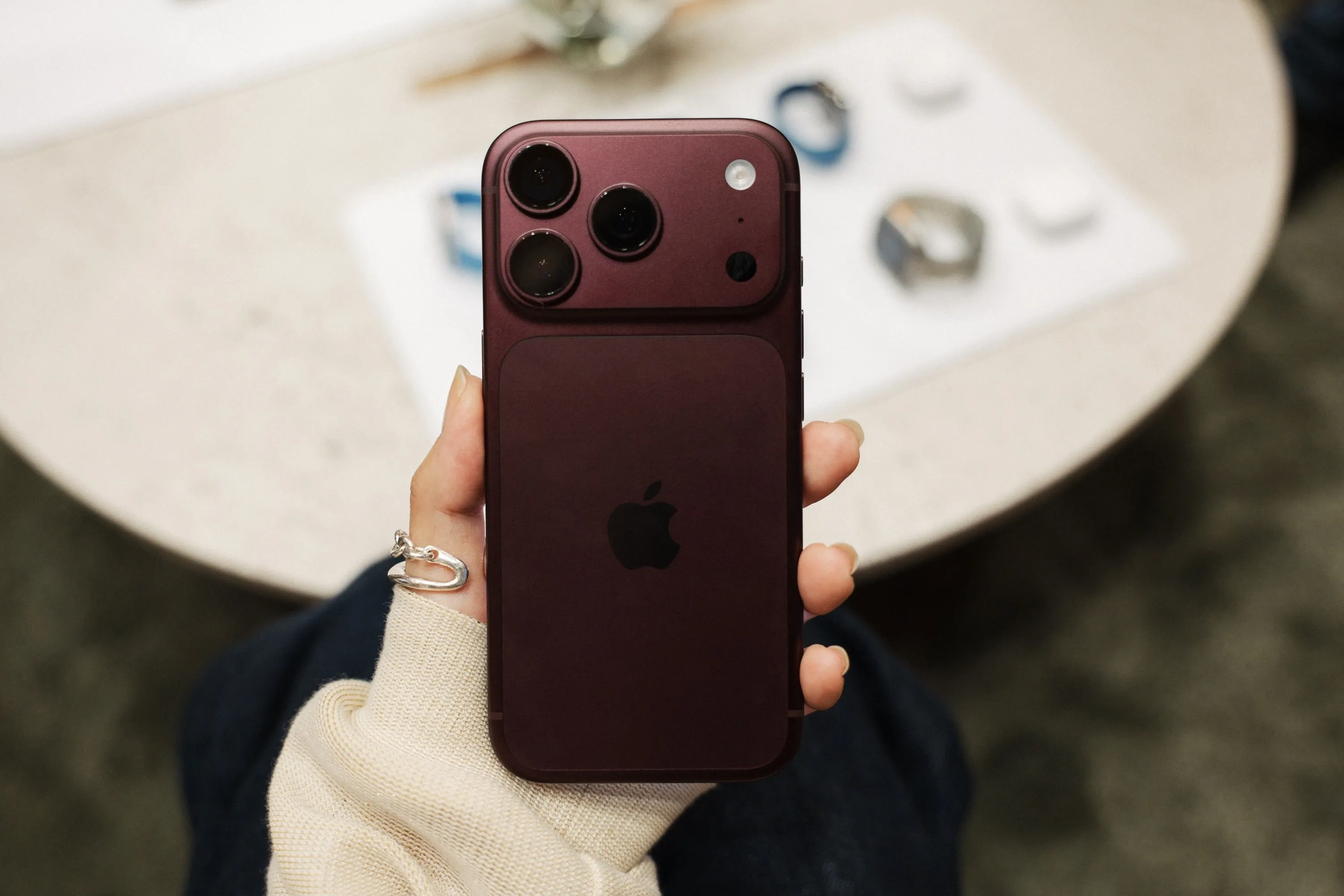 Un iPhone 18 Pro en color granate sostenido con una mano