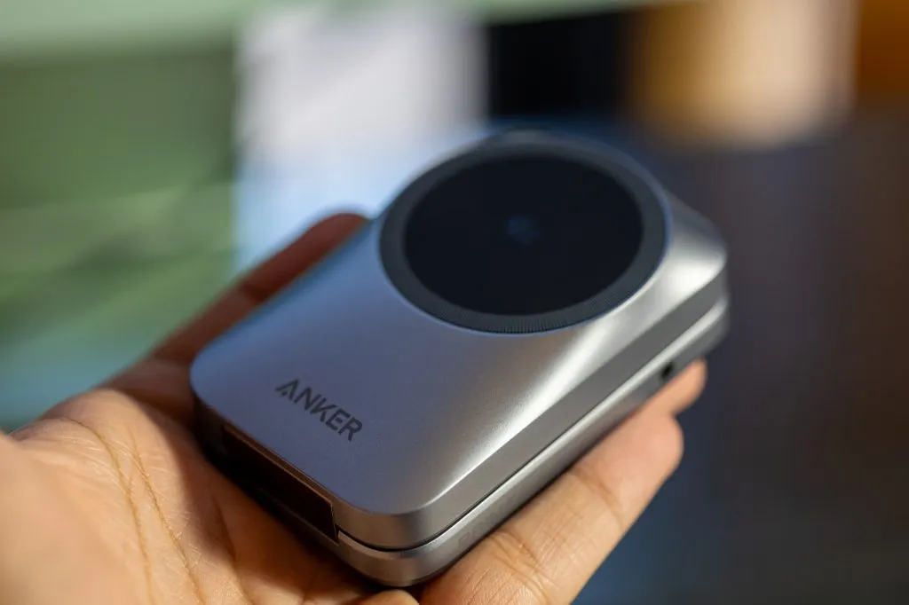 El cargador plegado en la mano, con el logotipo de Anker y la superficie de carga a la vista