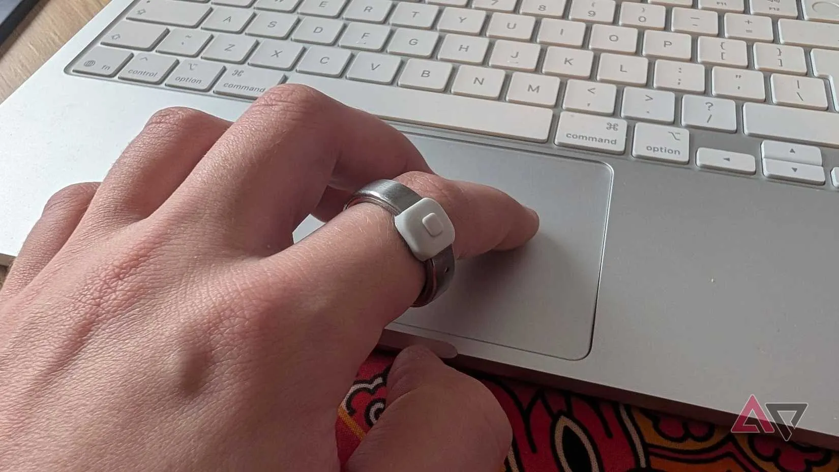 A hand using a trackpad with the Pebble Index 01 ring on