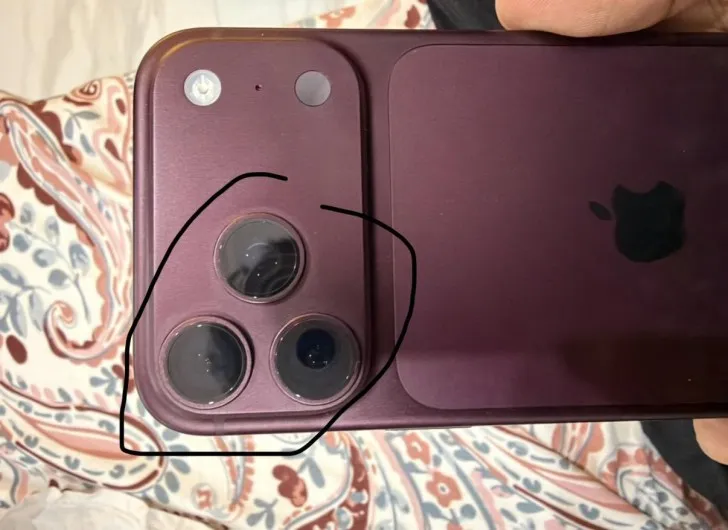 Close-up of a Burgundy iPhone 18 Pro with the camera area circled by hand