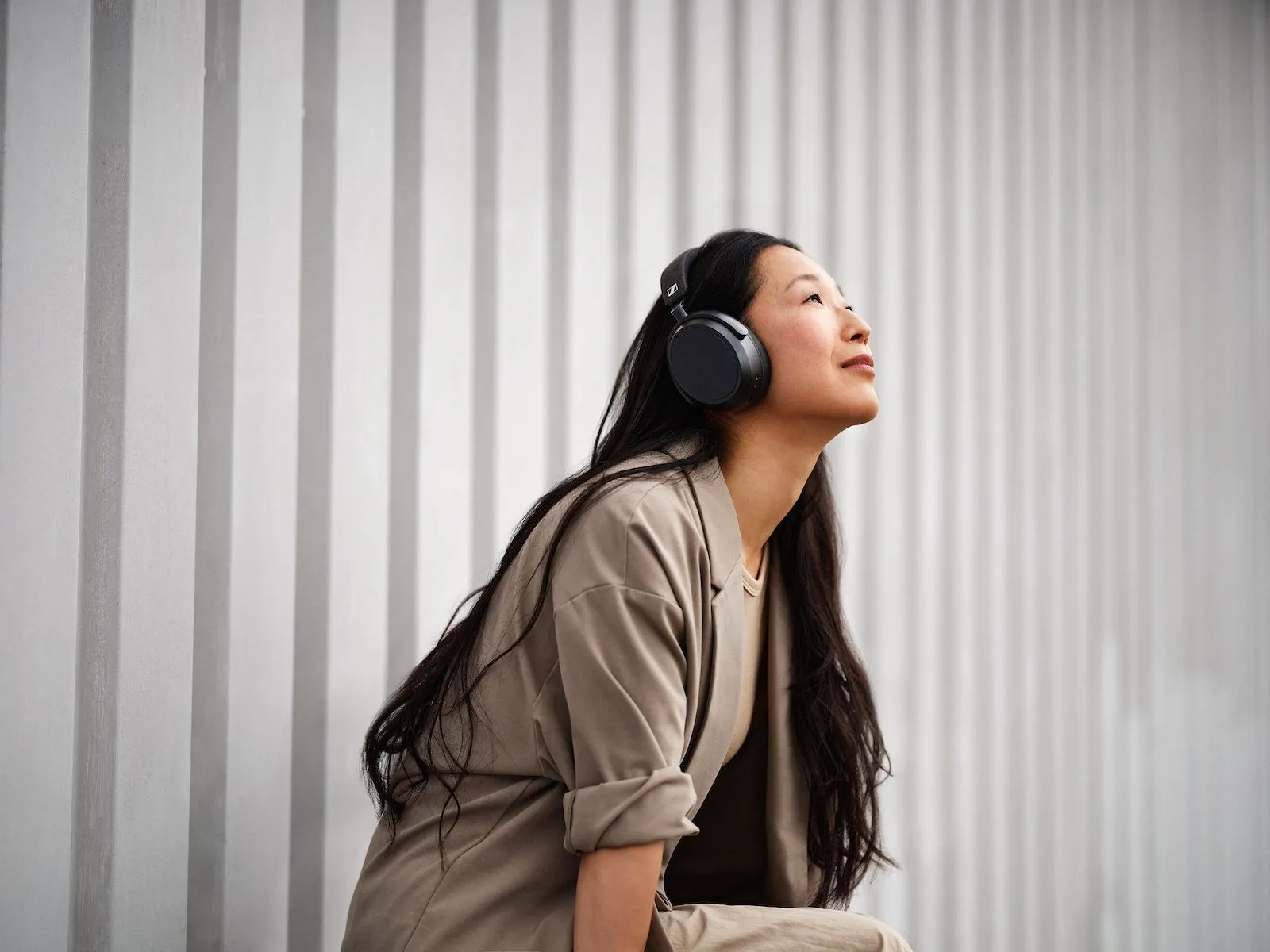 Person wearing the Sennheiser Momentum 4 headphones outdoors