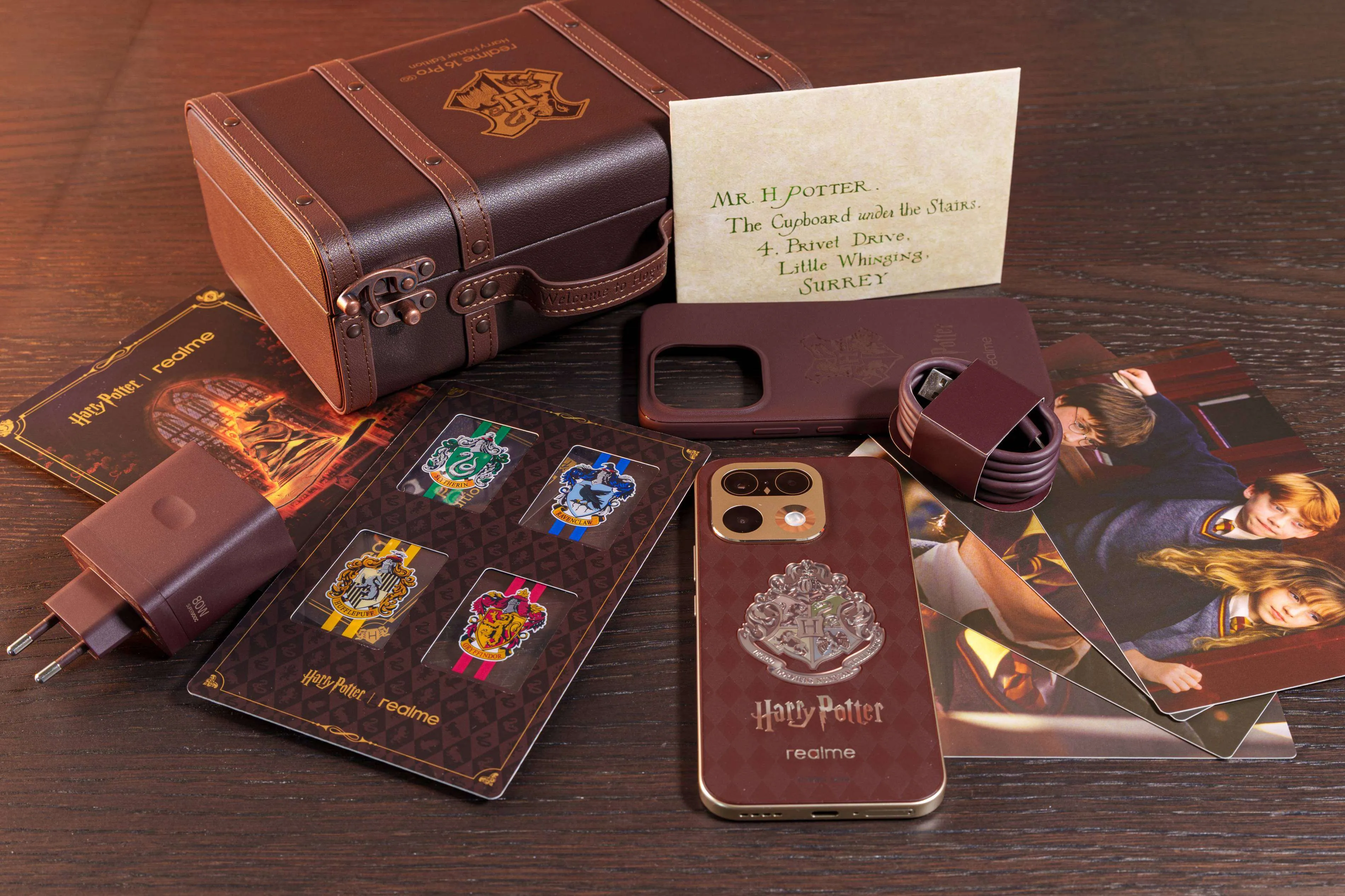 Maleta de Hogwarts abierta con el teléfono, el cargador, el cable, la funda, los marcapáginas de las cuatro casas y la carta de invitación