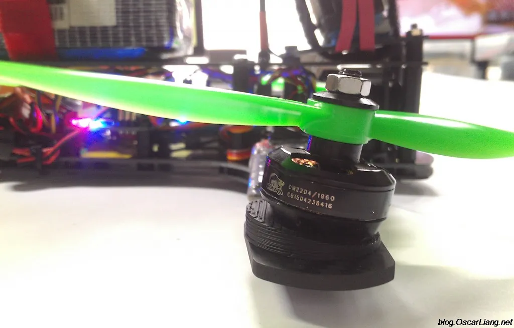 Close-up of an FPV motor with a green propeller mounted on a canted wedge on the frame arm