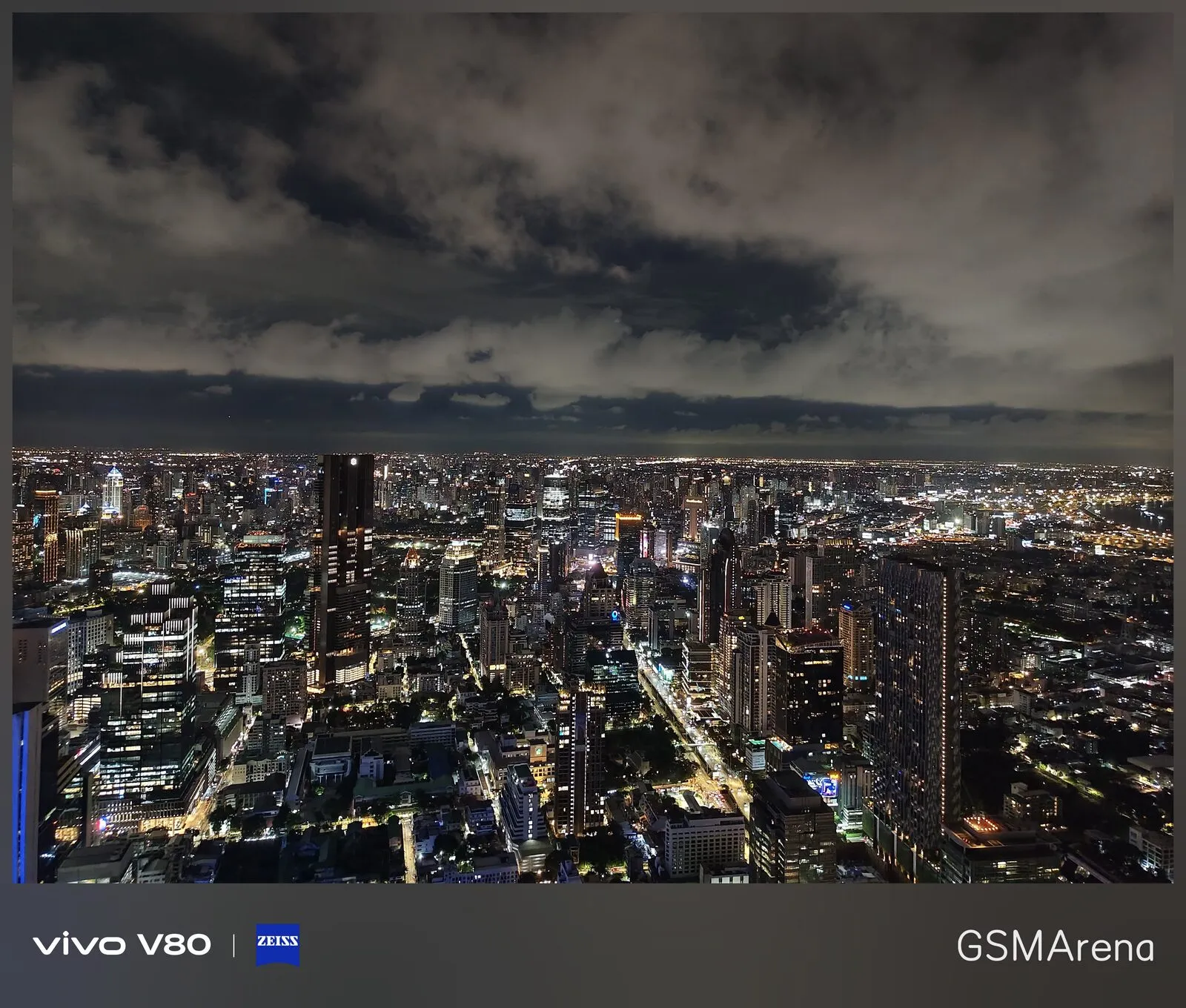 Vista nocturna de la ciudad con nubes densas y luces encendidas