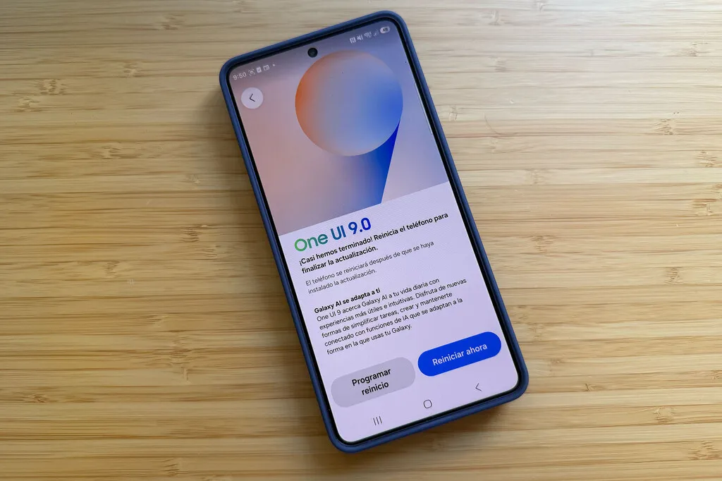 Un Galaxy sobre una mesa de madera con el aviso de One UI 9.0 pendiente de reiniciar
