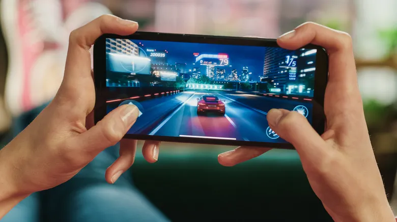 Persona jugando a un juego de carreras en un teléfono móvil