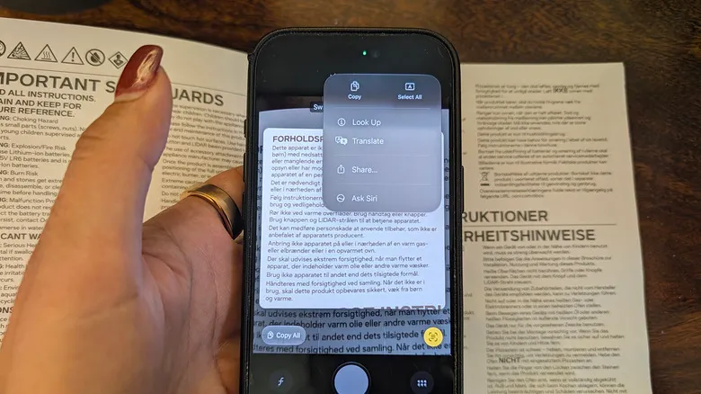 iPhone encuadrando un manual con las opciones de Live Text en pantalla