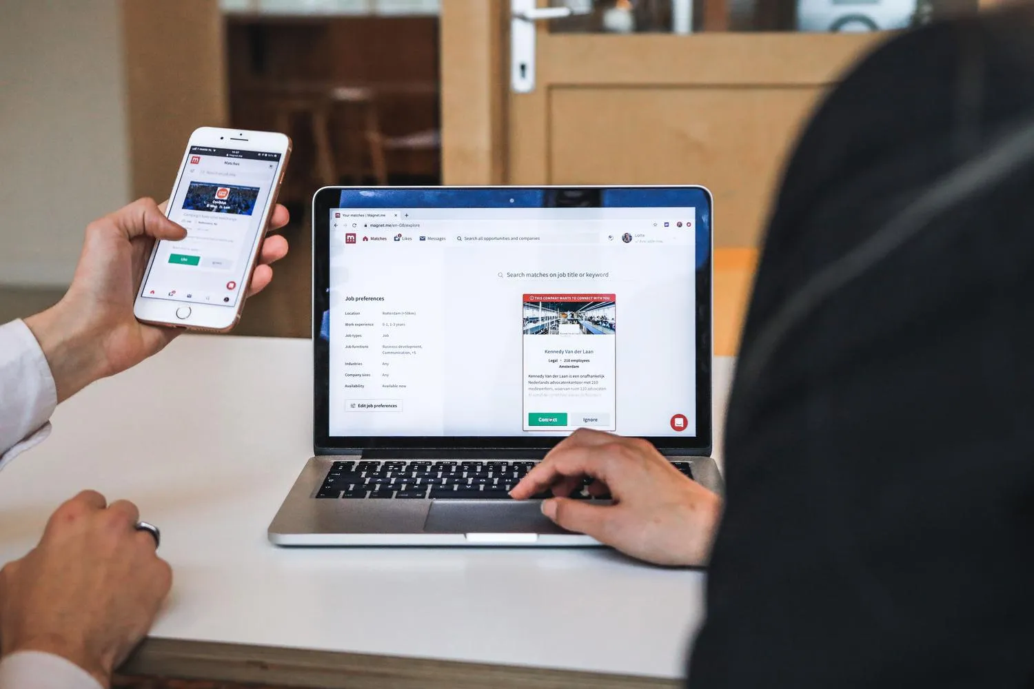 Persona usando el móvil y el portátil a la vez para gestionar información