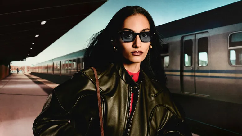 Una mujer con las Ray-Ban Meta Audio frente a un tren