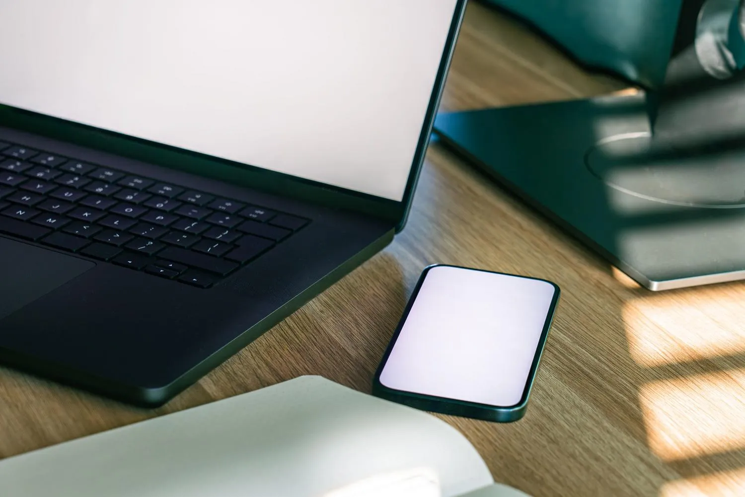 Espacio de trabajo con portátil y smartphone sobre un escritorio de madera