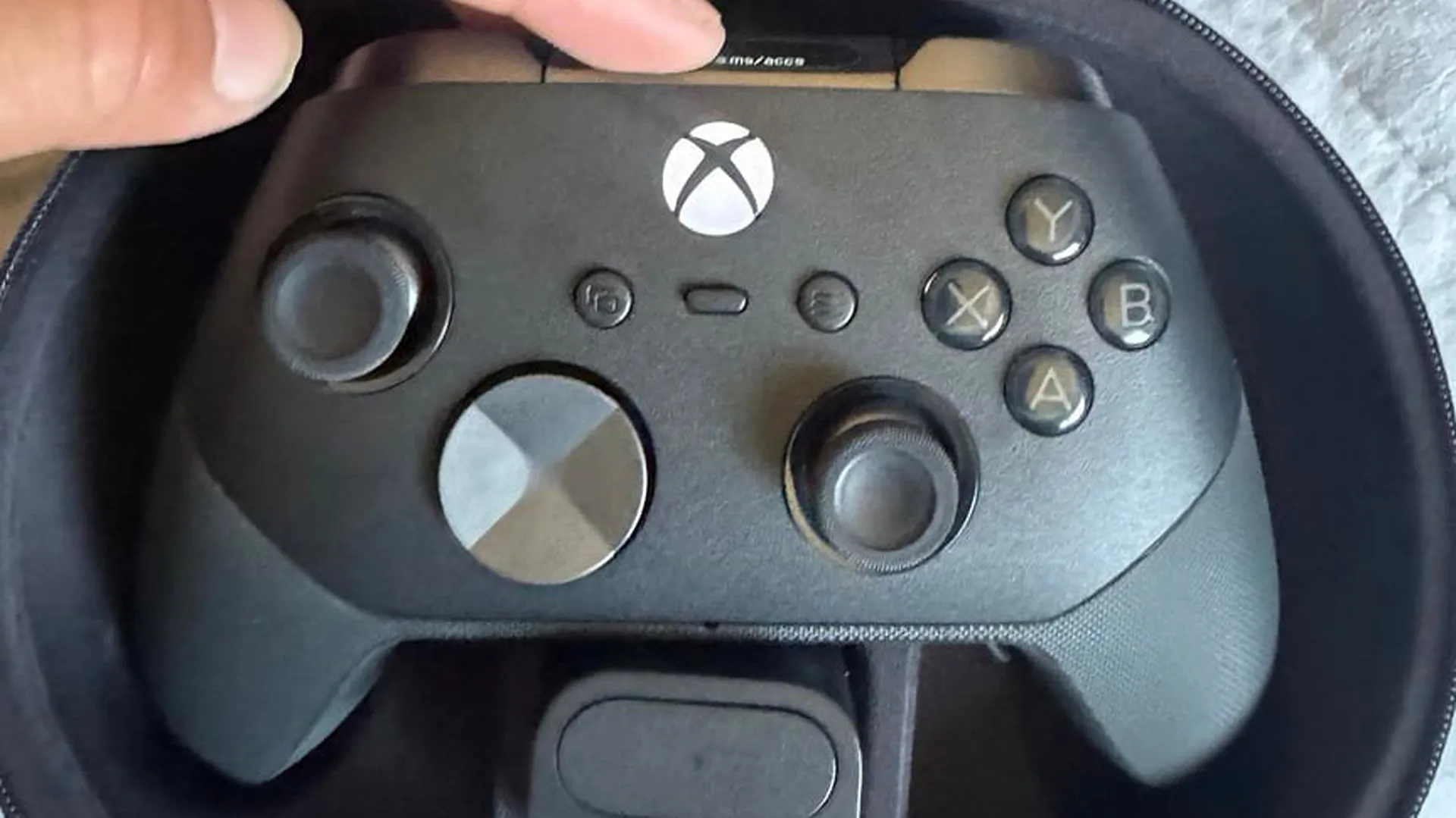 The leaked controller, with its metallic D-pad, sits inside a carrying case